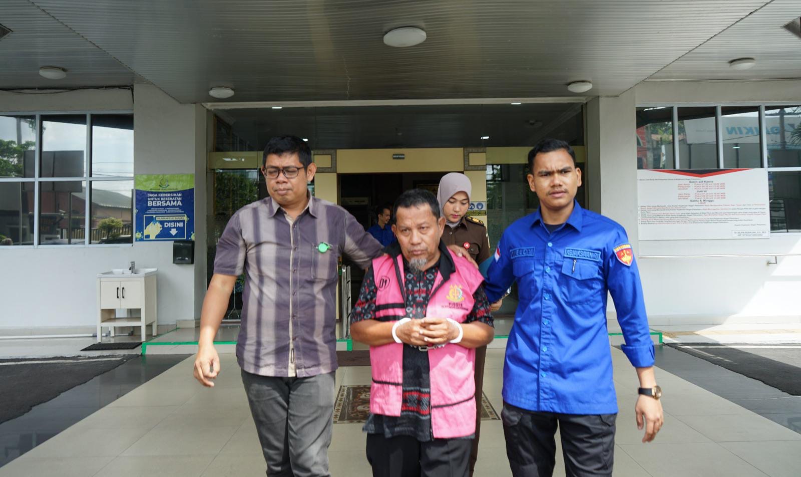 Tersangka penggelapan pajak, Erizon (rompi tahanan) digiring keluar Kantor Kejari Pekanbaru untuk ditahan di Rutan Kelas I Pekanbaru, Kamis (11/12/2025).