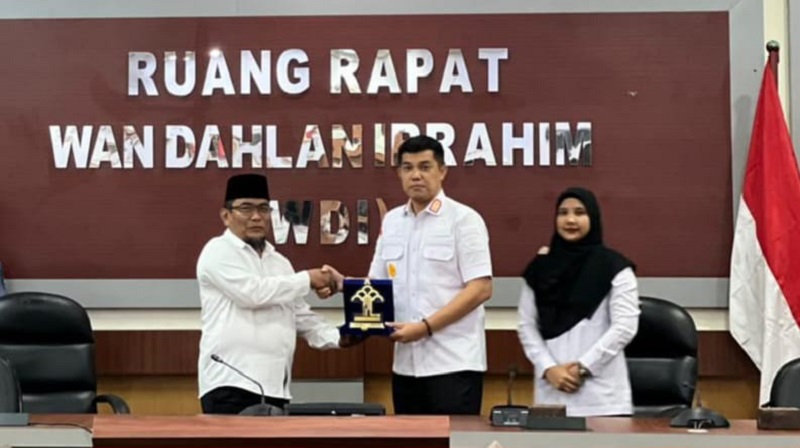Kepala Kanwil Kemenkum Riau Rudy Hendra Pakpahan (kanan) menyerahkan plakat penghargaan kepada Wakil Wali Kota Dumai, Rabu (10/12/2025).
