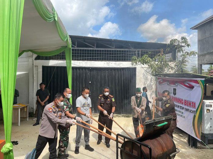 Kajari Inhil, Sugito SH bersama perwakilan Forkopimda memusnahkan barang bukti di halaman Kejari Inhil, Jalan Prof M Yamin, Tembilahan, Jumat (12/12/2025).