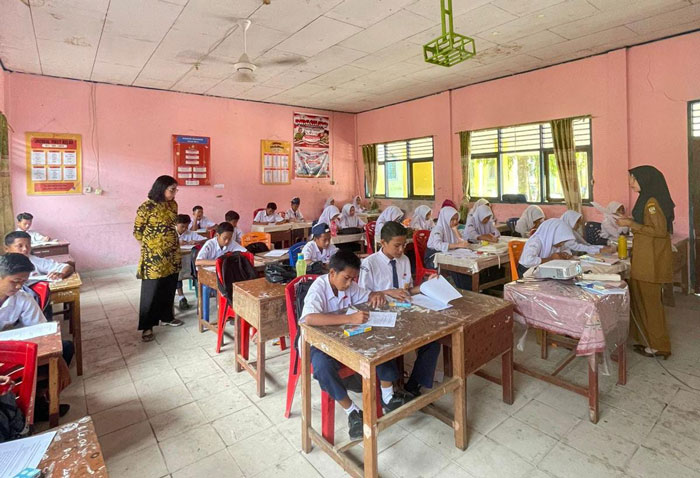 Dosen Jurusan Gizi Poltekkes Kemenkes Riau.Yessi Marlina, S.Gz., MPH,(kiri) memberikan edukasi gizi menggunakan konsep &ldquo;Isi Piringku&rdquo;di SMPN 1 Kampar, Jumat (12/12/2025).