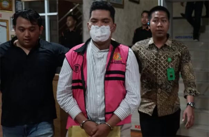 JA digiring keluar dari Kantor Kejari Pekanbaru untuk dititipkan di Rutan Kelas I Pekanbaru, Jumat (12/12/2025) jelang tengah malam.