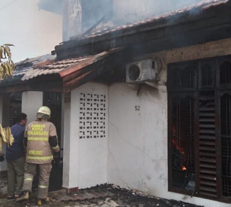 Petugas pemadam kebakaran tengah melakukan upaya pemadaman sebuah rumah permanen dua lantai di Jalan Akasia Gang Aksana No. 52, Kelurahan Tangkerang Utara, Kecamatan Bukit Raya, Sabtu (13/12/2025)