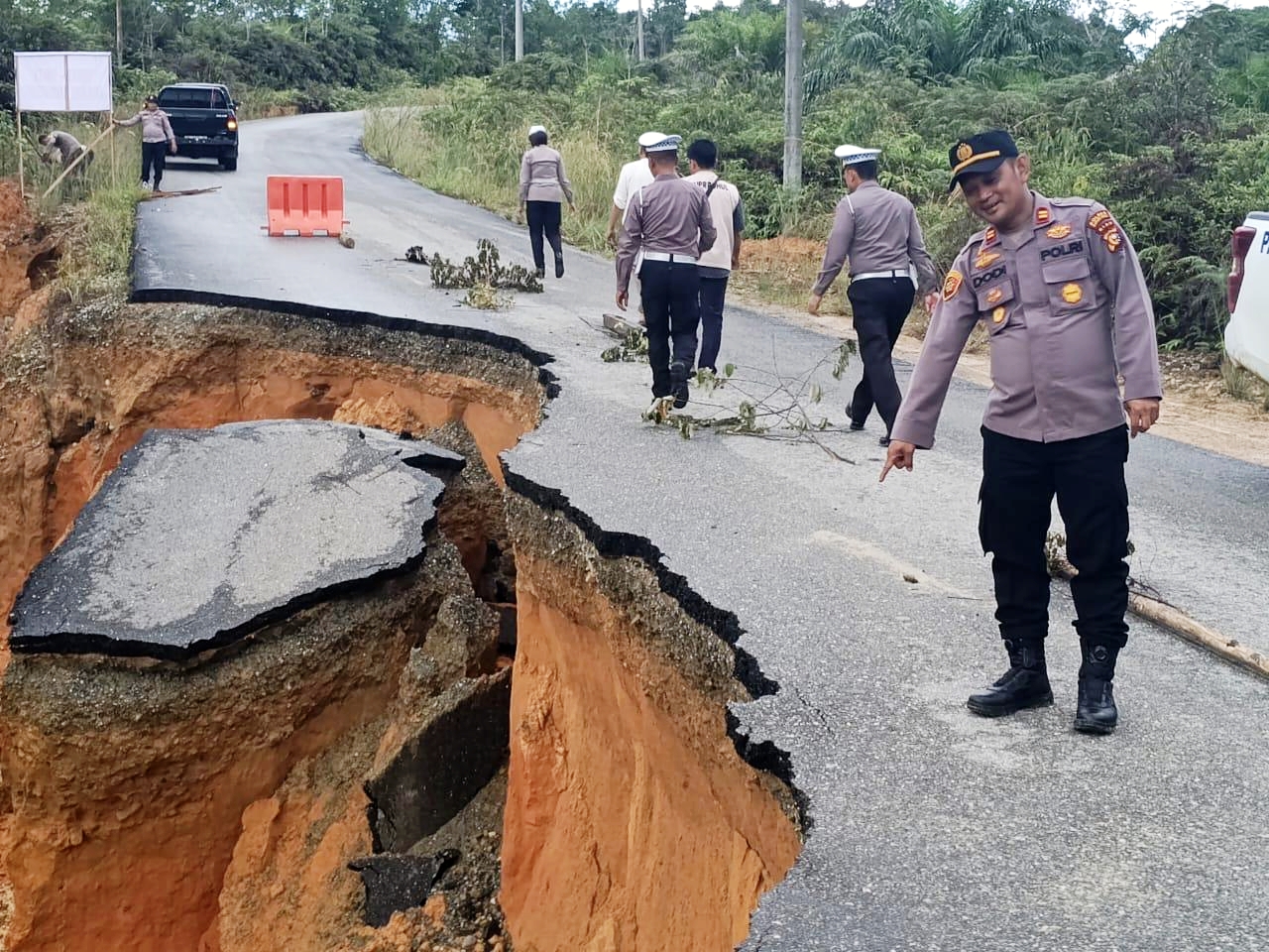 Personel dari pihak Kepolisian melihat lokasi longsor serta memasang rambu-rambu pembatas di lokasi titik longsor ruas Jalan Lintas Provinsi Riau-Sumbar di Jalan Lintas Provinsi Riau-Sumbar di Rohul,