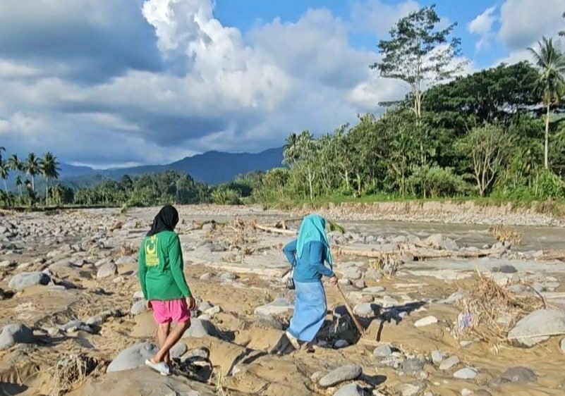 Keluarga saat mencari jenazah Ipda Angga Mufajar di sekitar Jembatan Kembar, Silaing Bawah, Padang Panjang, belum lama ini.