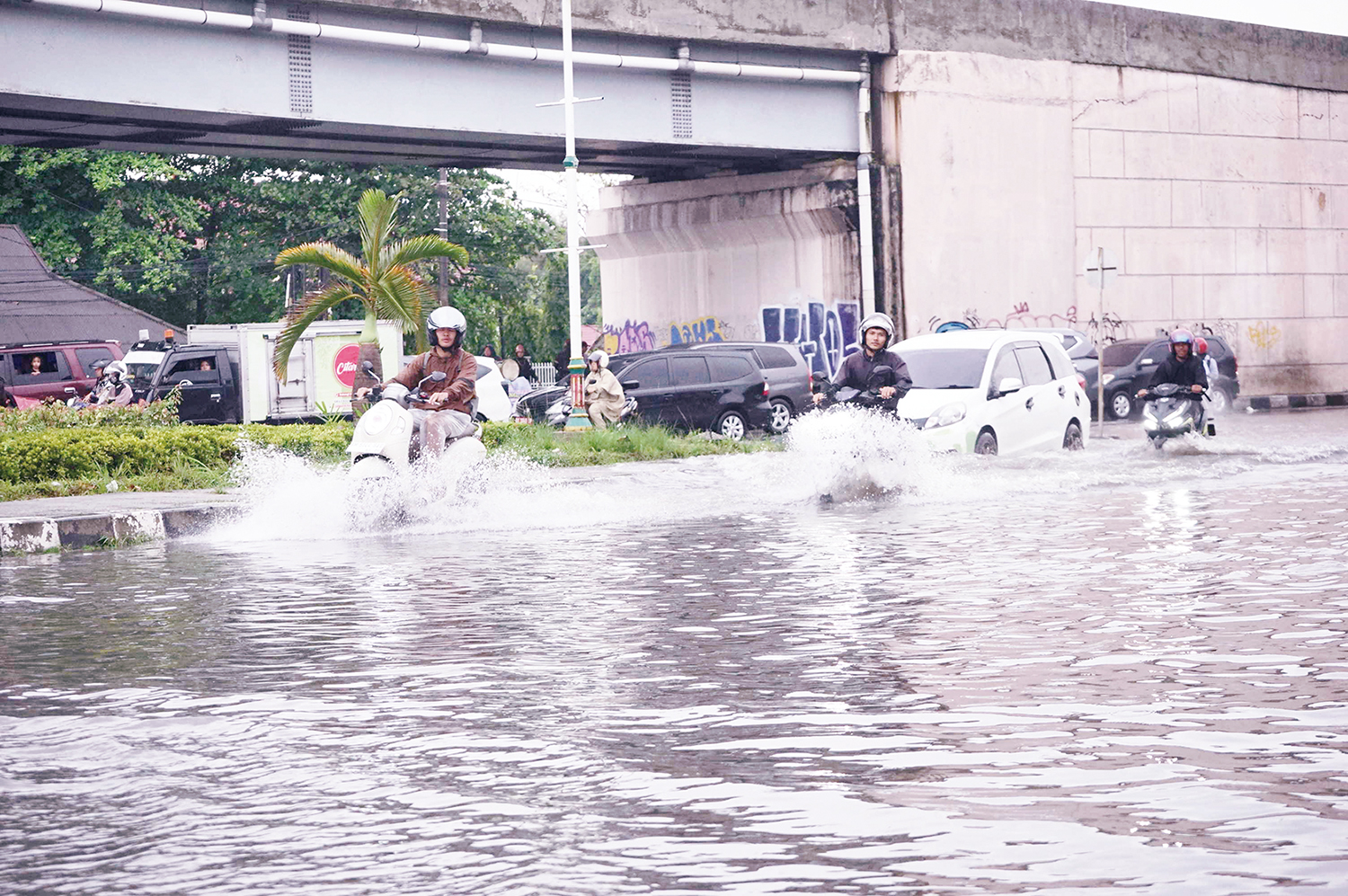 Pengendara melewati genangan air di Jalan HR Soebrantas simpang Jalan Soekarno/Hatta dekat flyover Pasar Pagi Arengka, Pekanbaru , Ahad (14/12/2025) sore.