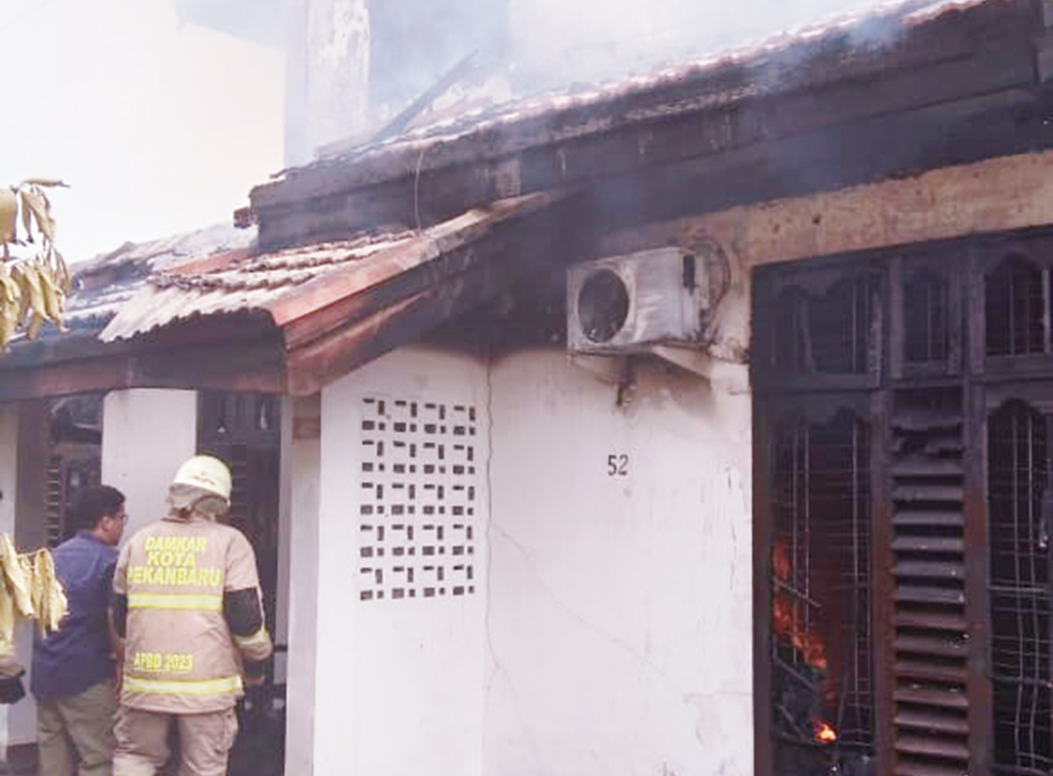 Petugas pemadam keba&shy;karan melakukan upaya pemadaman api yang membakar sebuah rumah di Jalan Akasia, Kecamatan Bukit Raya, Sabtu (13/12/2025) siang.