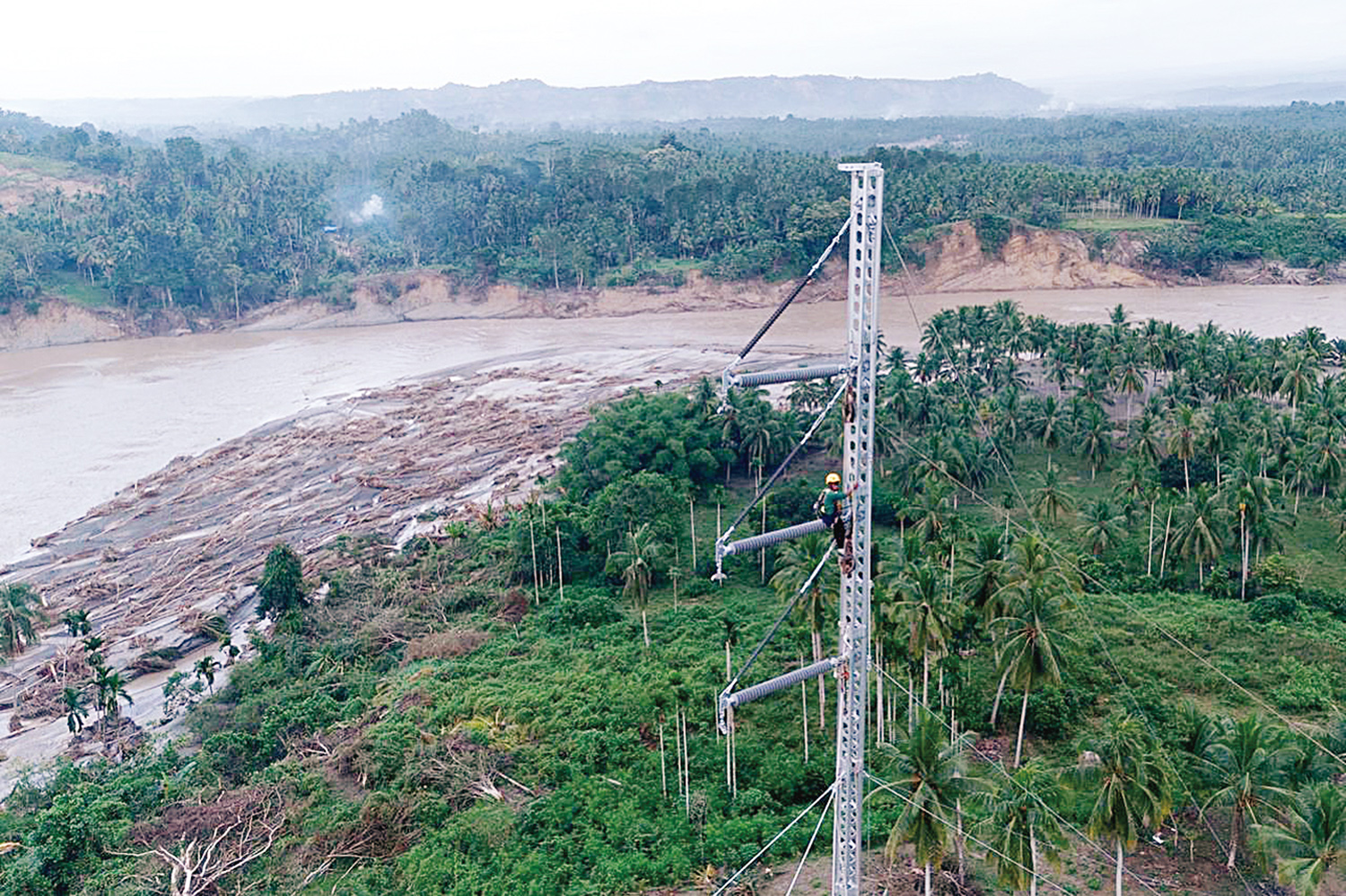 Petugas PLN ketika melakukan penyambungan kabel transmisi Saluran Udara Tegangan Tinggi (SUTT) 150 kilovolt (kV) Arun-Bireuen di atas  emergency tower yang telah didirikan.