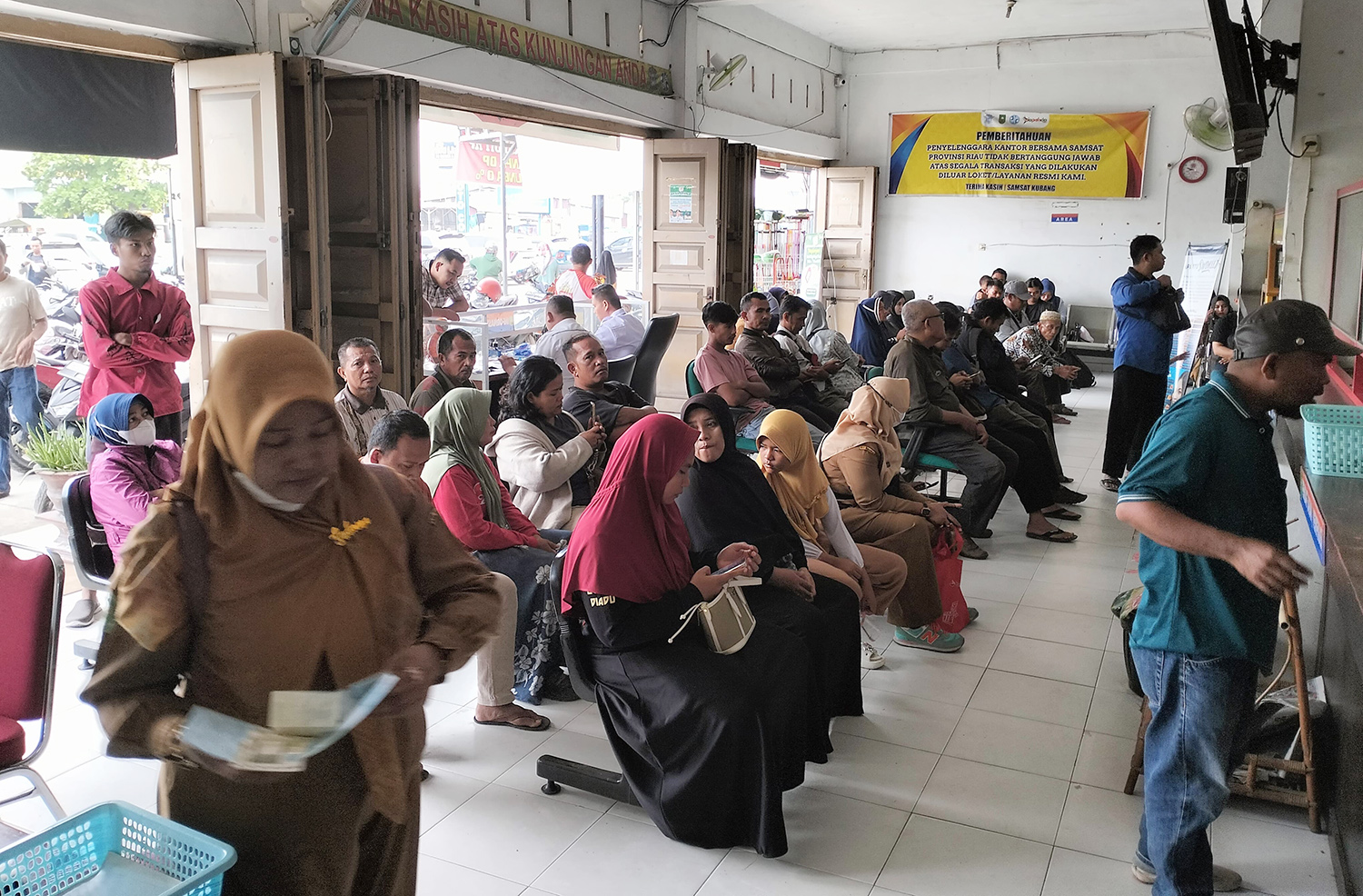 Masyarakat antre membayar pajak kendaraan bermotor di Samsat Kubang, Kampar, Senin (15/12/2025).