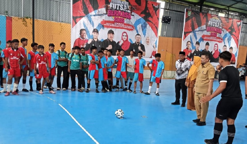 Camat Mandau Riki Rihardi memandang bola pembukaan Turnamen Futsal Bermasa 2025 antarsiswa di Lapangan Futsal Onix, Jalan Rambutan, Kelurahan Air Jamban, Selasa (16/12/2025).