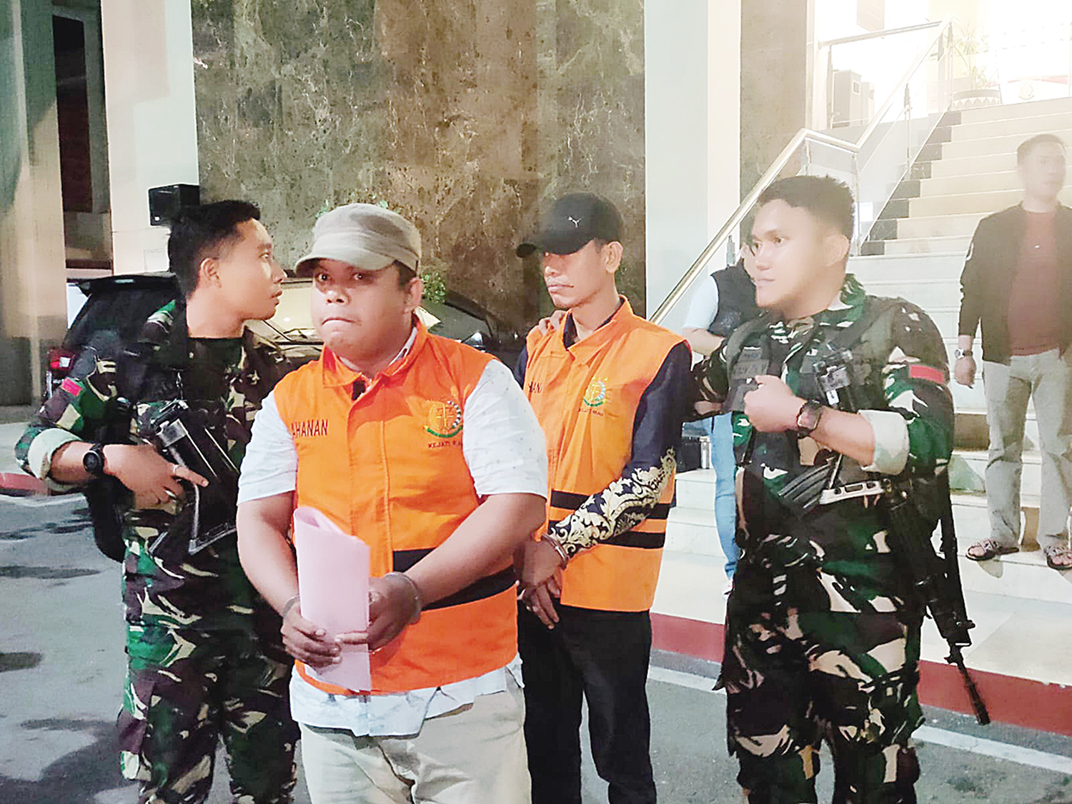 MA dan DS digiring ke luar Kantor Kejati Riau untuk dititipkan ke Rutan Kelas I Pekanbaru, Senin (15/12/2025) jelang tengah malam.