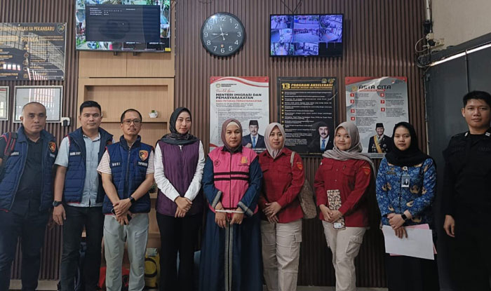 Tersangka korupsi Novianty Faisal (rompi merah muda) saat diserahkan ke JPU Kejari Pekanbaru pada Rabu (17/12/2025).