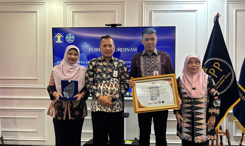 Kepala Kanwil Kemenkum Riau Rudy Hendra Pakpahan menerima penghargaan Terbaik I Legislasi Daerah tingkat nasional dari Direktur Jenderal Peraturan Perundang-Undangan Kemenkum RI Dhahana Putra.