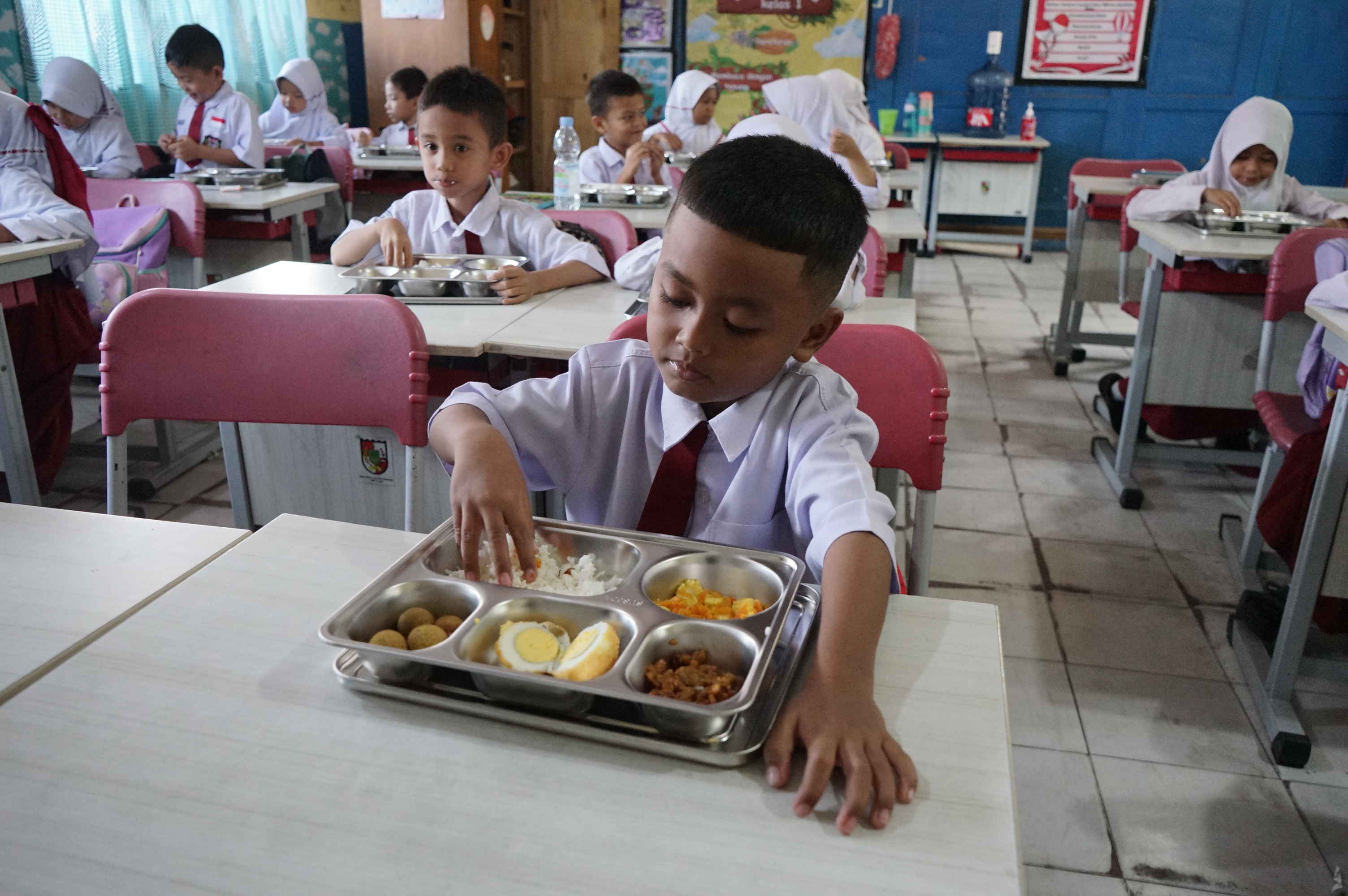 Murid  menyantap menu Makan Bergizi Gratis (MBG) di SDN 99 Pekanbaru, Senin  (6/10/2025). Sejumlah sekolah di Pekanbaru sudah mulai menikmati program MBG dari pemerintah.