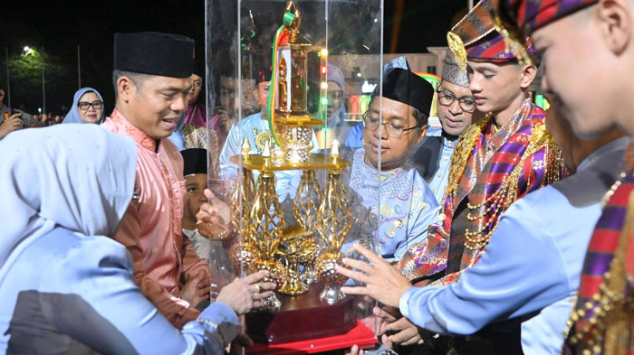 Camat Bangko Pusako Riwansyah (dua dari kiri) menerima piala bergilir dari Wabup Jhony Charles, usai diumumkan Bangko Pusako keluar sebagai juara umum pada MTQ XX Rohil tahun 2025, di Bagansiapiapi