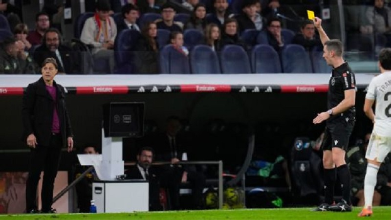 Wasit Alejandro Muniz Ruiz menunjukkan kartu kuning kepada pelatih kepala Sevilla Mattias Almeyda selama pertandingan melawan Real Madrid.