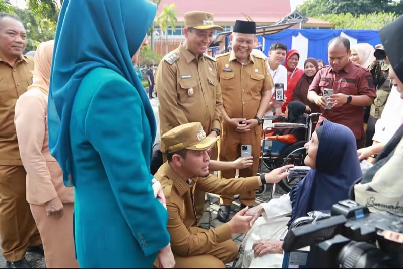 Wako Pekanbaru Agung Nugroho didampingi Wawako Pekanbaru Markarius Anwar dan Ketua TP PKK Pekanbaru Sulastri Agung menyapa seorang ibu lansia saat peringatan hari ini, Senin (22/12/2025).