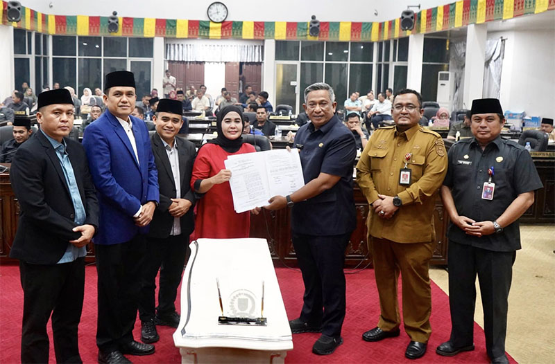 Ketua DPRD Rohul Hj Sumiartini bersama Bupati Anton menunjukkan Berita Acara Persetujuan RAPBD Tahun Anggaran 2026 dalam rapat paripurna di Gedung DPRD, Senin (22/12/2025) malam.