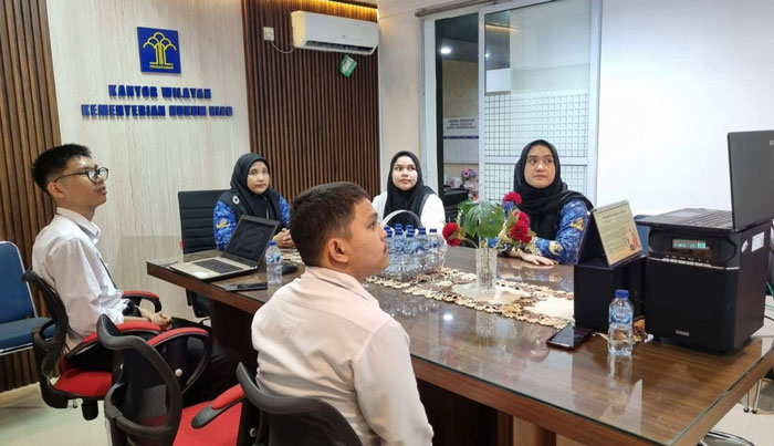 Kepala Divisi P3H Kanwil Kemenkum Riau Yeni Nel Ikhwan (paling belakang) bersama tim mengikuti Sosialisasi E-Report 2025 secara virtual dari ruang kerjanya, Senin (22/12/2025).