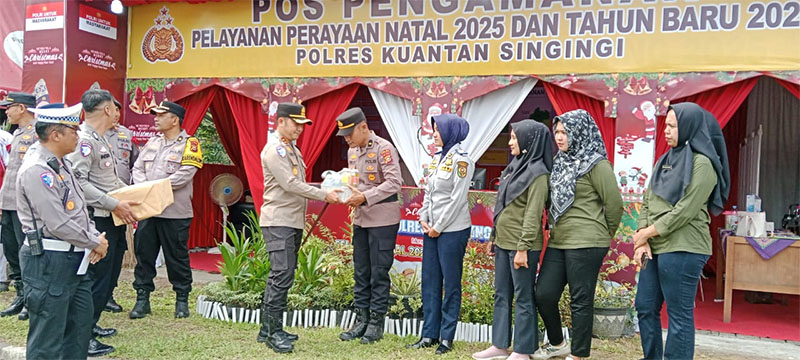 Kapolres Kuansing AKBP Raden Ricky Pratidiningrat memberikan bingkisan pada personel yang bertugas di Posyan Tugu Cerano saat peninjauan, Rabu (24/12/2025).