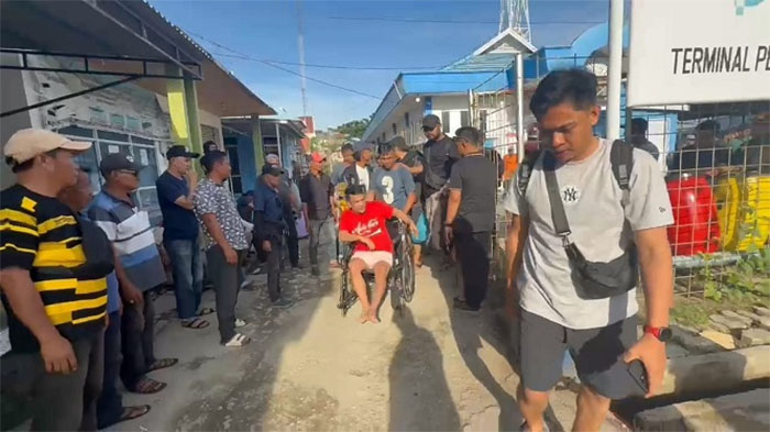Iwan Tanjung, menggunakan kursi roda setelah dihadiahi timah panas dan dibawa petugas kepolisian menuju Polres Inhil.