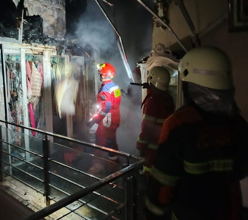 Petugas Damkar berupaya melakukan pemadaman bangunan yang terbakar di Jalan Utama Sari, Kelurahan Tangkerang Selatan, Kecamatan Bukit Raya, Pekanbaru, Selasa (23/12/2025) malam.
