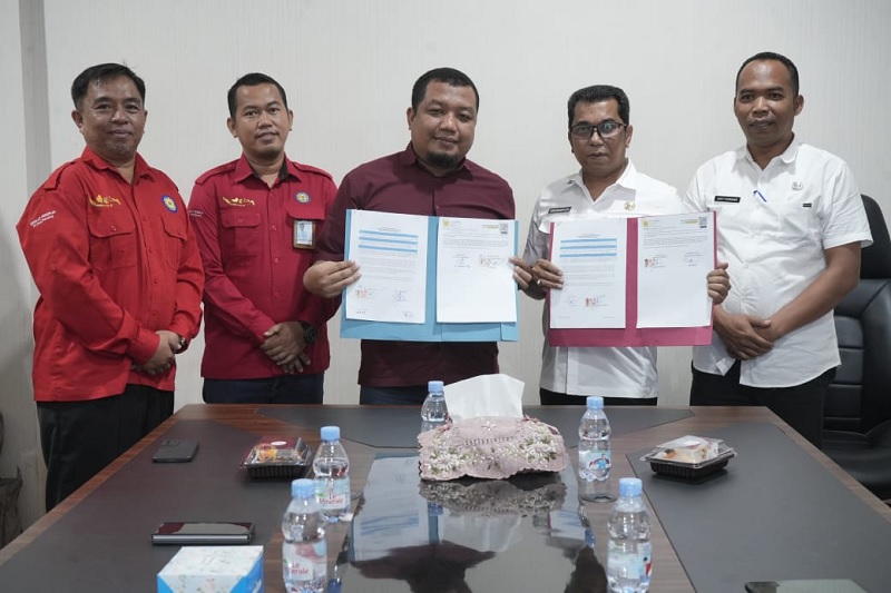 Sekda Kuansing, Zulkarnain ST MSi (dua dari kanan) memperlihatkan MoU bersama PT PLN, Rabu (24/12/2025) di Kantor Bupati Kuansing