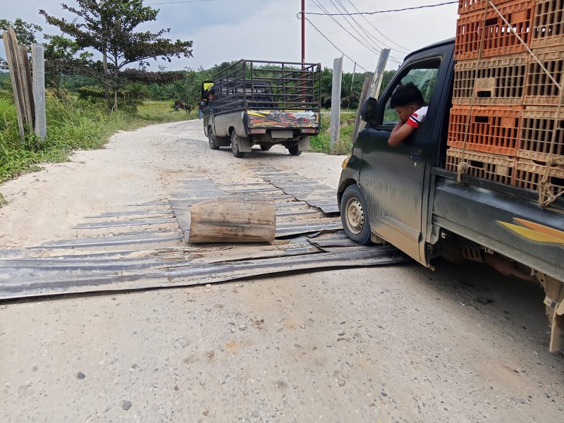 Jembatan darurat sungai Sinambek -Desa Pulau Komang Sentajo Raya, terlihat rusak dan tetap dilalui kendaraan, Kamis (25/12/2025).
