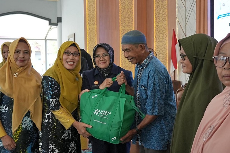 Ketua TP PKK Kabupaten Siak Siti Sarifah bersama Bupati Siak Afni Z membagikan paket sembako di Balairung Datuk Empat Suku, Komplek Rumah Rakyat, Jumat (26/12/2025).