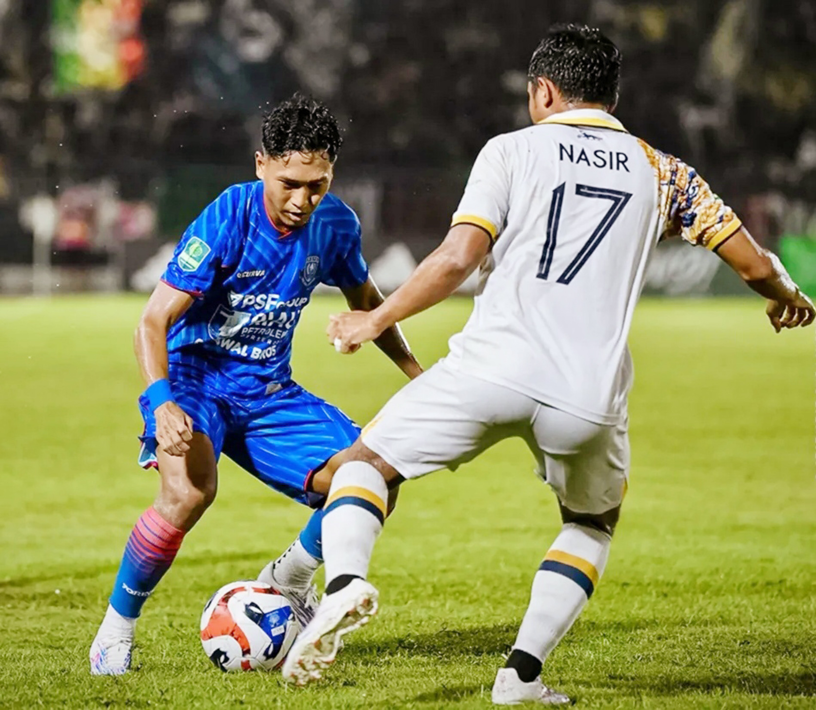 Pemain PSPS Pekanbaru, Asir Asiz (kiri) berusaha melewati adangan pemain Persikad Depok, Nasir, dalam pertandingan Liga 2 di Stadion Kaharuddin Nasution, Pekanbaru, Sabtu (27/12/2025) malam.
