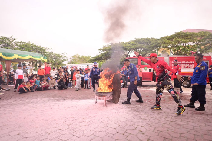 Petugas Damkar Bengkalis melakukan  simulasi edukasi bahaya kebakaran dan penggunaan APAR di Lapangan Tugu Bengkalis, Ahad (28/12/2025).