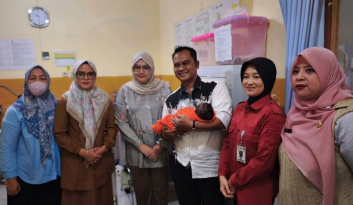 Kanit Reskrim Polsek Bukit Raya, Ipda Zamhur, bersama pihak rumah sakit Bhayangkara saat menggendong bayi, pada Senin (29/12/2025).