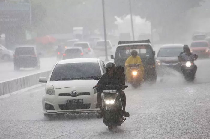 Pengendara menerobos hujan deras di kawasan Pasar Pagi Arengka, Pekanbaru, baru-baru ini.