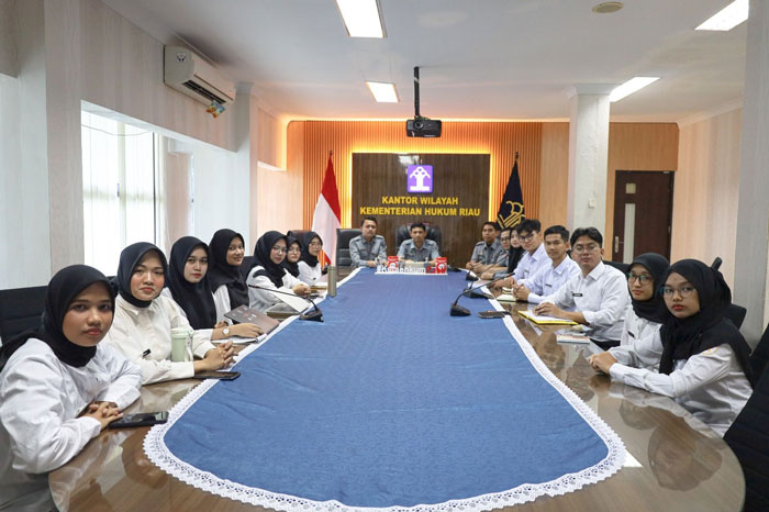 Kabag Tata Usaha dan Umum Kanwil Kemenkum Riau Dean Satria (kanan paling belakang) bersama staf jajaran dan peserta magang mengikuti  MAGANGHUB Soft Skill Programme  secara daring,Senin (29/12/2025).