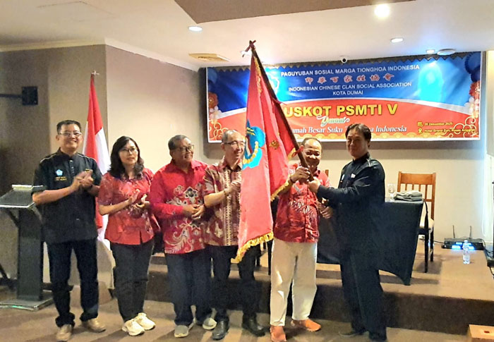 Ketua Harian PSMTI Riau Jailani Tan ( dua kiri) menyerahkan pataka kepada Ketua PSMTI Kota Dumai Zainal Arif (kiri) saat muskot PSMTI Dumai, Senin (29/12/2025).