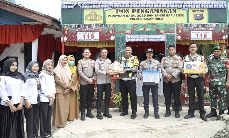 Kapolres Rohul AKBP Emil Eka Putra SIK MSi memberikan bingkisan kepada perwakilan personel saat meninjau Pos Pam Nataru di Simpang TB Kecamatan Tandun, Senin (29/12/2025).