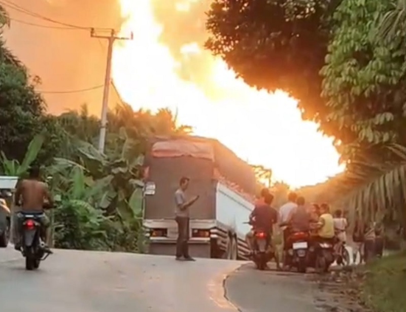 Pengendara terlihat memunda melintasi jalan di sekitaran lokasi pipa gas terbakar di Desa Batu Ampar, Kecamatan Kemuning, Kabupaten Inhil, Jumat (2/1/2026).
