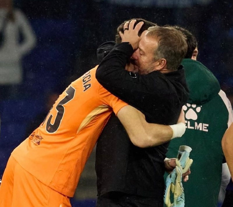 Pelatih Barcelona Hansi Flick memeluk kiper Joan Garc&iacute;a setelah kemenangan mereka atas Espanyol.