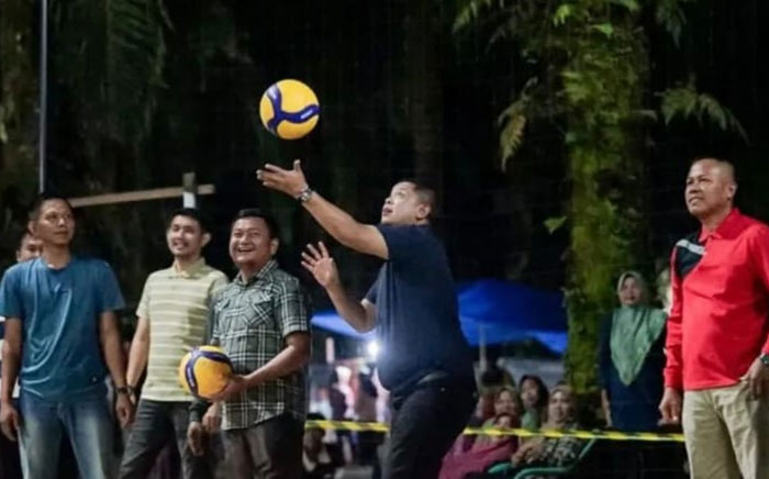 Camat Mandau Riki Rihardi memukul bola pembukaan Turnamen Bola Voli JVC Desa Harapan Baru Cup Tahun 2026 di Lapangan Bola Voli JVC, Desa Harapan Baru.