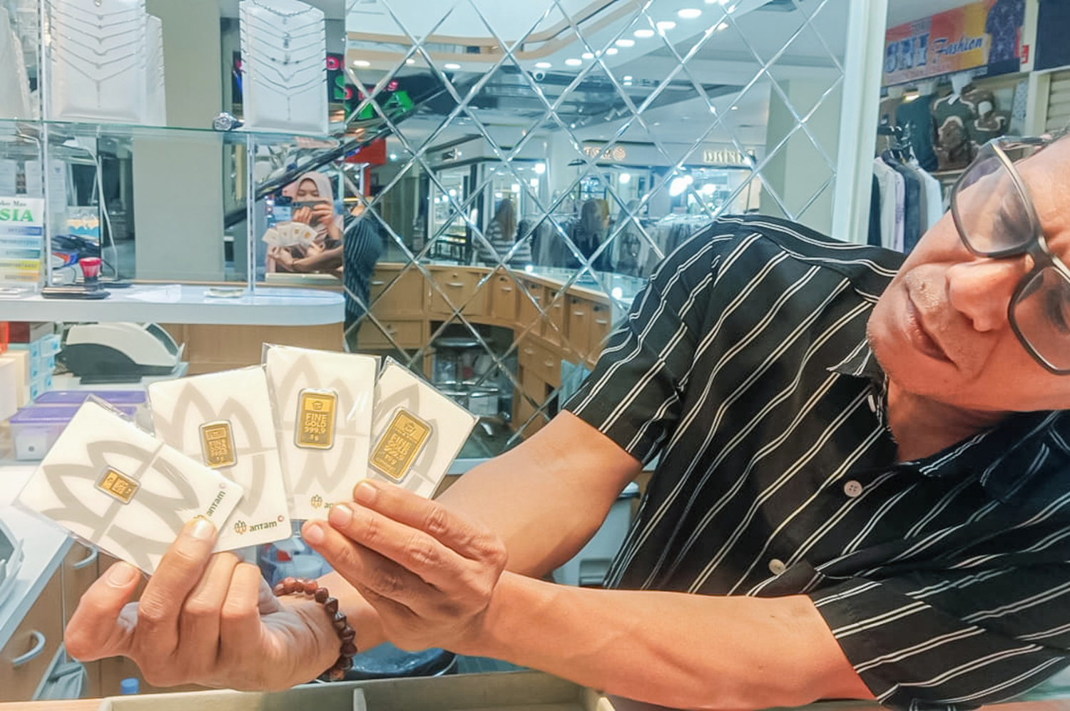 Pemilik toko emas memperlihatkan emas Antam, belum lama ini. Dalam waktu dekat harga jual emas Antam diprediksi meroket seiring melonjaknya harga emas dunia.