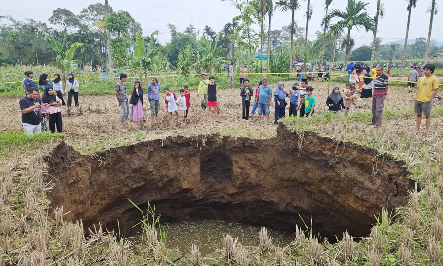 Warga beramai-ramai melihat sinkhole di areal persawahan Jorong Tepi, Nagari Situjuah Batu, Kecamatan Situjuah Limo Nagari, Kabupaten Limapuluh Kota, Sumatera Barat, Ahad (4/1/2026).