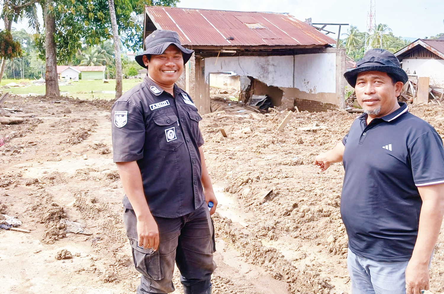 Wali Nagari Salareh Aia Timur A Fauzi (kiri) berada di lokasi bekas rumahnya yang disapu galodo saat menemani Ketua Masjid Masyithah Pekanbaru Drs H Novri Wahyudi MSi saat meninjau lokasi bencana, Sabtu (3/1/2026).