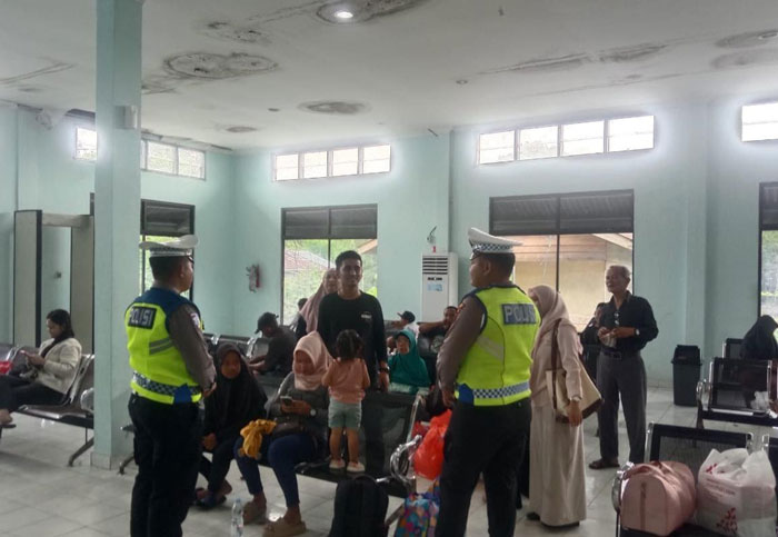Personel Satlantas Polres Siak berbincang dengan warga yang menunggu keberangkatan di Pelabuhan Tanjung Buton, Desa Mengkapan, Kecamatan Sungai Apit, Kabupaten Siak, Senin (5/1/2026).