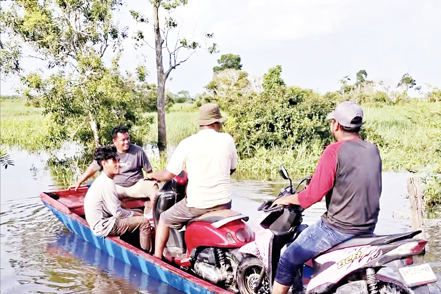 Sejumlah pengendara roda dua memanfaatkan jasa angkutan penyeberangan menggunakan pompong di jalan provinsi Dusun 1 Desa Sontang, Kecamatan Bonai Darussalam, Rokan Hulu menuju batas Duri, Bengkalis, Senin (5/1/2026).