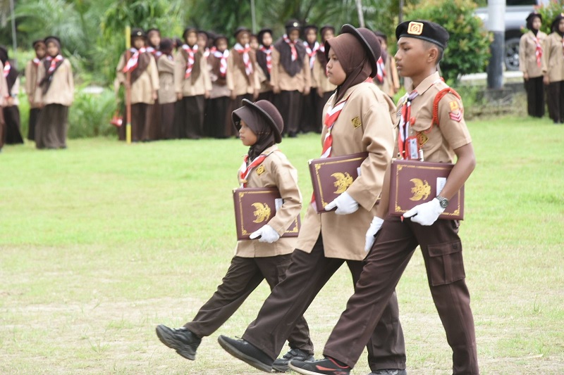 Anggota perkemahan akbar Gerakan Pramuka Gugus Depan Darussalam tetap semangat meski diguyur hujan saat apel di Halaman Pondok Pesantren Darussalam Desa Pematang Duku Timur Kecamatan Bengkalis.