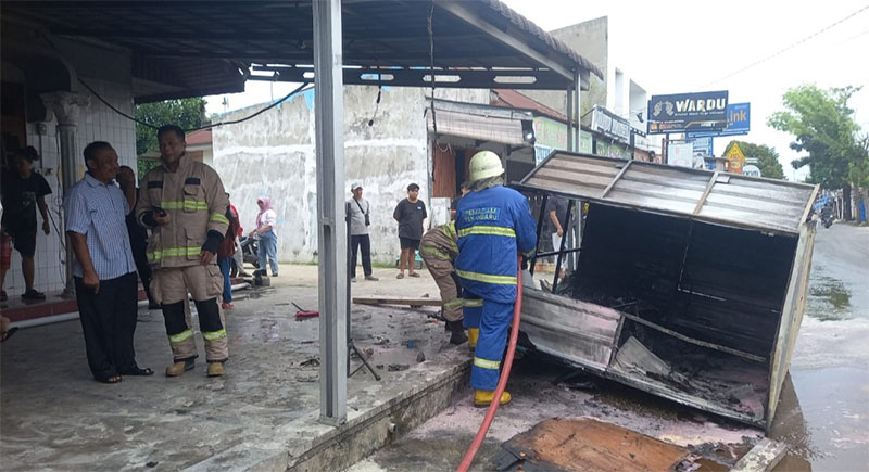 Petugas melakukan proses pemadaman api yang menghanguskan box jualan es teh jumbo di Jalan Air Dingin, Kelurahan Air Dingin, Kecamatan Bukit Raya, Kota Pekanbaru, Jumat (9/1/2026).