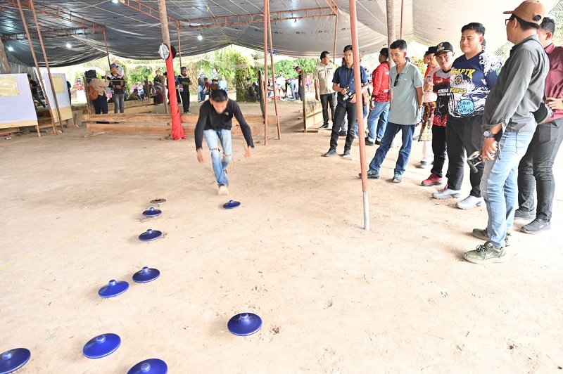 Para peserta turnamen gasing piring se-Riau memutar gasing permulaan dibukanya turnamen di Lapangan Gasing Terbuka Desa Bantan Sari, Sabtu (10/1/2026).