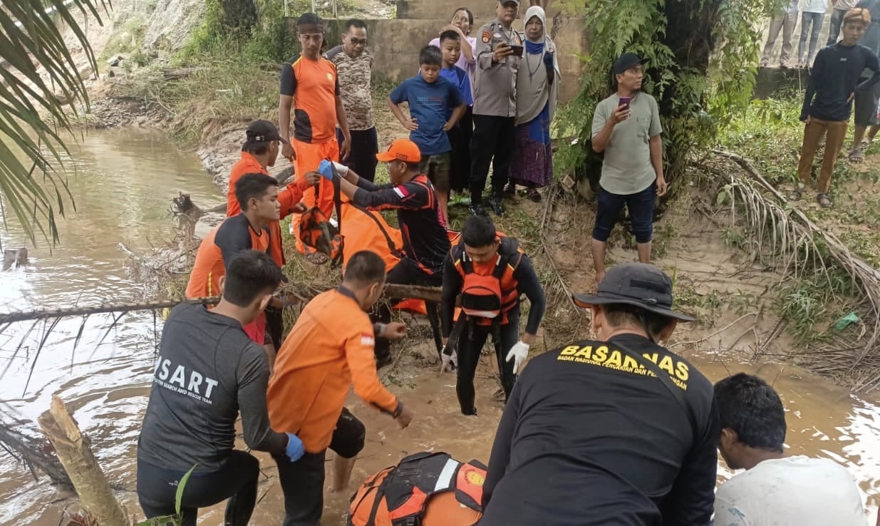 Tim gabungan dari TRC BPBD Rohul, Basarnas, Kepolisian sektor setempat melakukan proses evakuasi korban El Mahesa Pramana (8) dari aliran Sungai Ngaso, di Ujung Batu, Rohul, Ahad (11/1/2026).