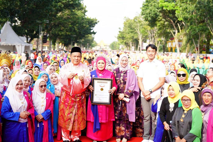 Plt Gubri SF Hariyanto didampingi Ketua BKOW Riau Adrias memperlihatkan piagam rekor MURI tari Zapin masal 6000 peserta di jalan Gajah Mada Pekanbaru, Ahad (11/1/2026).