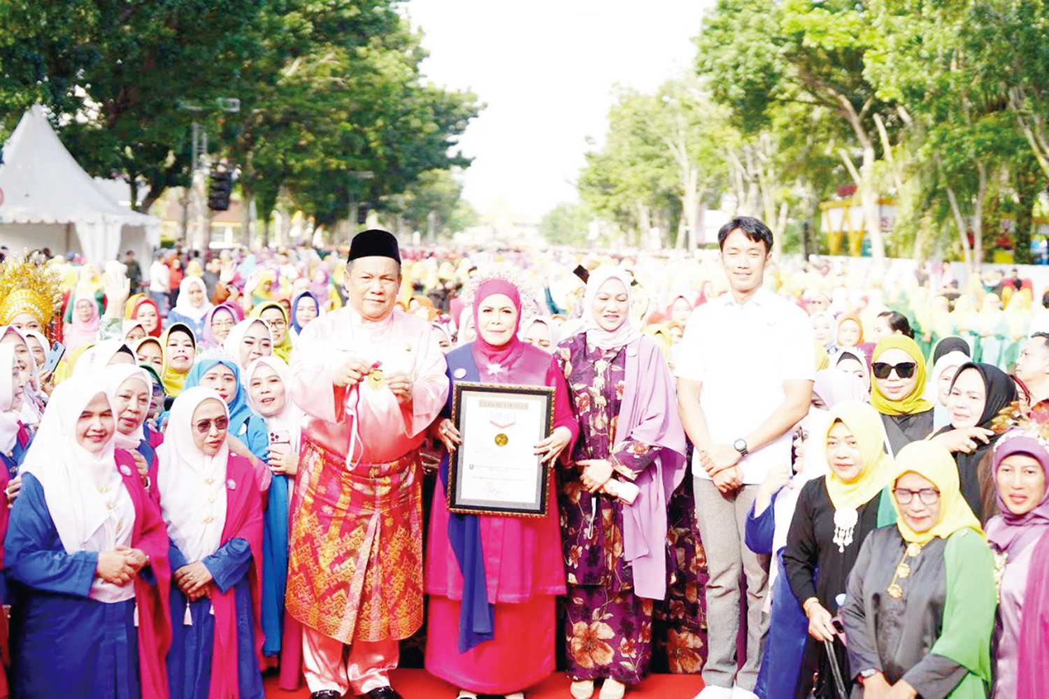 Pelaksana Tugas Gubernur Riau SF Hariyanto didampingi Ketua BKOW Riau Adrias memperlihatkan Piagam Rekor MURI Tari Zapin Massal 6.000 peserta di Pekanbaru, Ahad (11/1/2026).