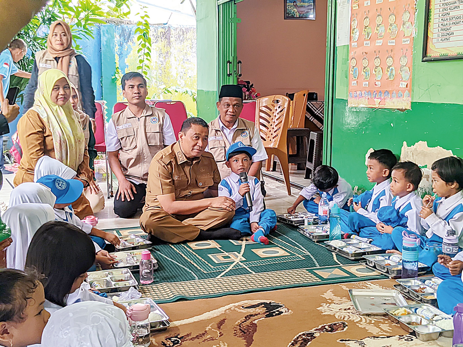 Wakil Wali Kota Pekanbaru Markarius Anwar berbaur dengan duduk bersama anak-anak saat pemberian Makan Bergizi Gratis di TK Negeri 6 Pekanbaru, Senin (12/1/2026).